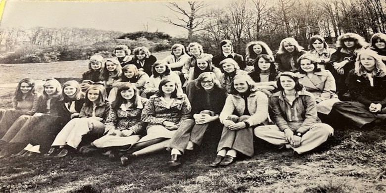 svartvit fotografi av ett tjugotal ungdomar sittandes i gräset