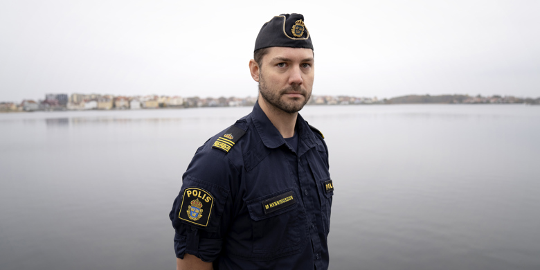 Polisman i uniform med havet som bakgrund